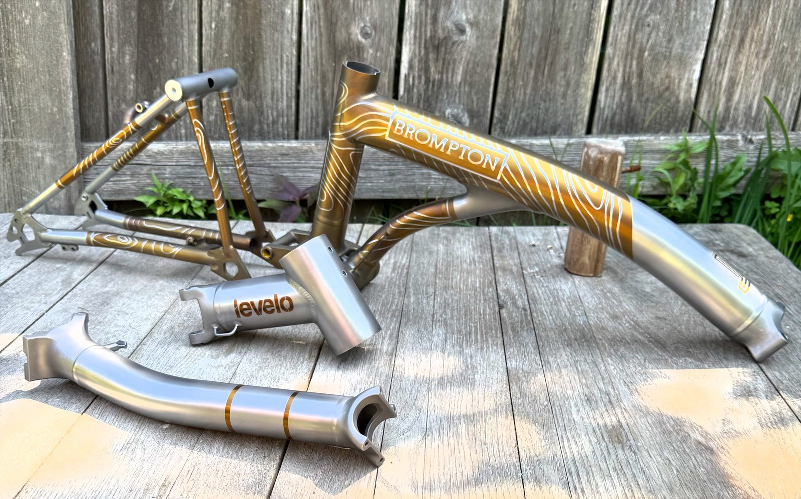 Set of gold anodized titanium tubes and components laid out on a deck