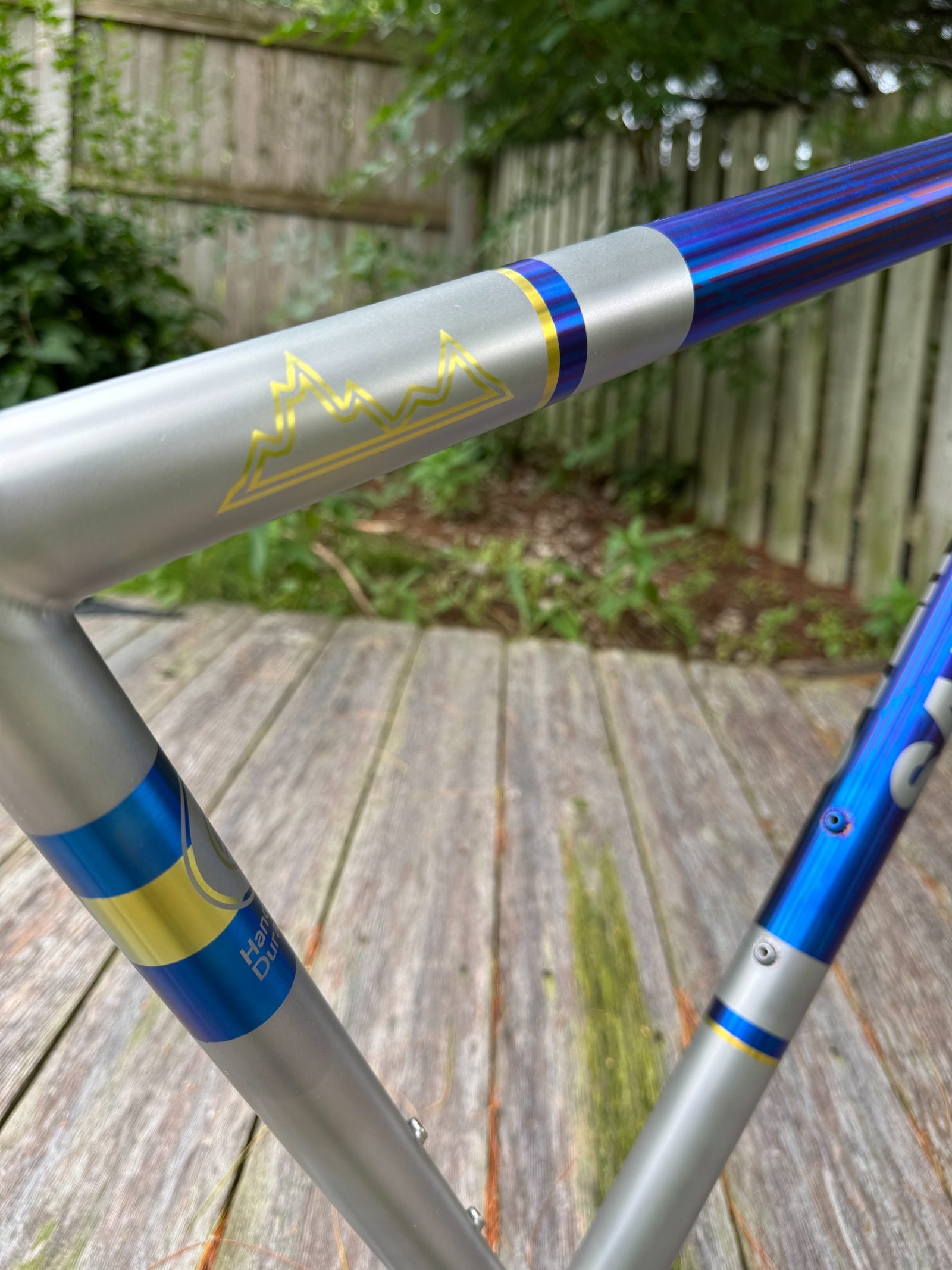 Close-up of blue and gold anodized accents at a titanium tube junction